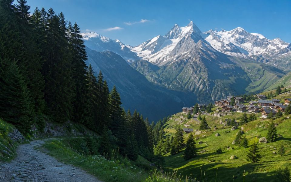 Alpine valley, mountain village and snow-capped peaks of Europe
