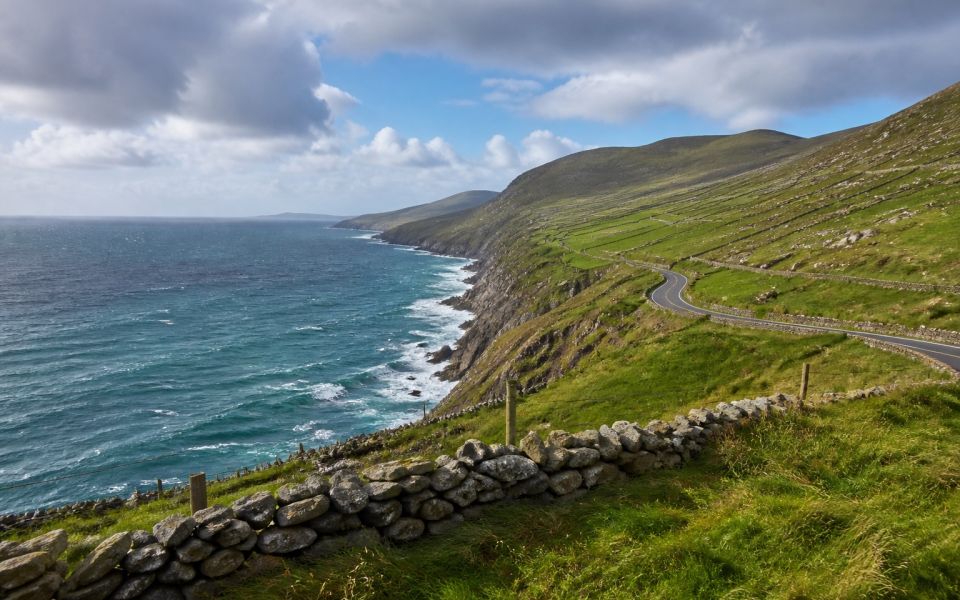 Ireland's Atlantic coastline, green slopes, stone walls and coastal road