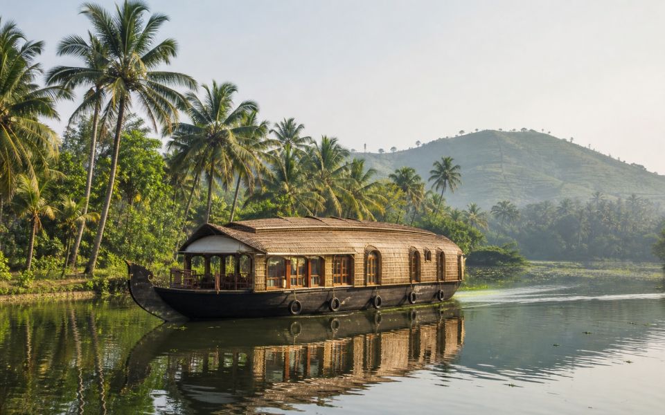 A houseboat on the Kerala backwaters among palm trees and green banks