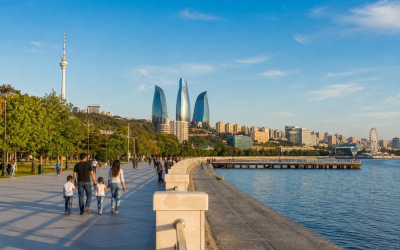 Families stroll along Baku Boulevard alongside the Caspian Sea