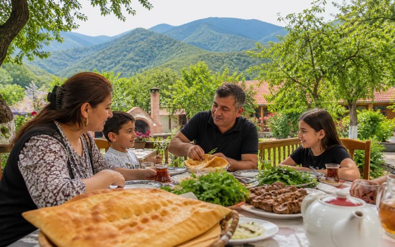 Азербайджанский обед с хлебом, мясом, зеленью и чаем в саду Габалы