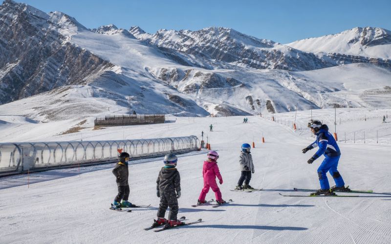 An instructor works with children on the training slope of Shahdag