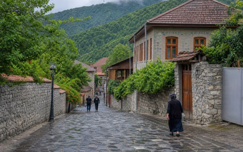 Мощеная улица, каменные дома и зеленые предгорья в старом Шеки