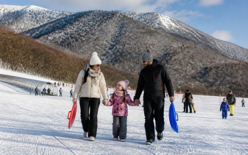 Семья с санками на безопасном снежном склоне Туфандага