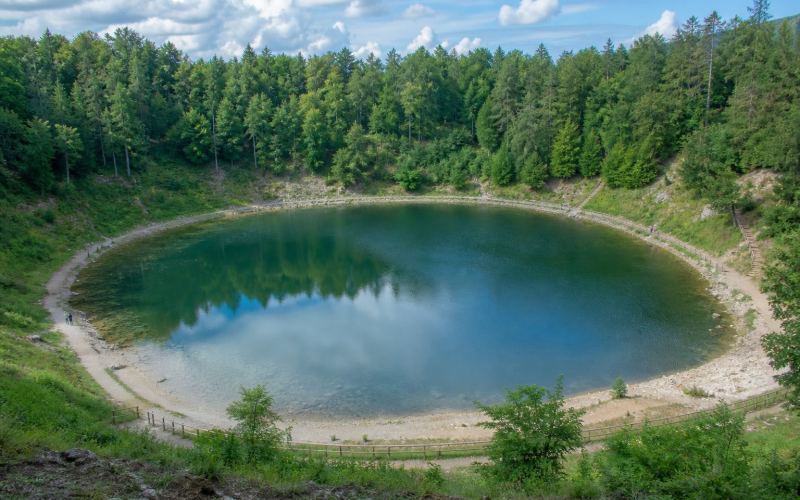 Кратерное озеро Каали среди леса на острове Сааремаа