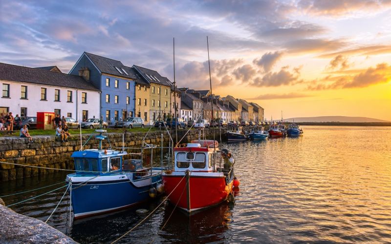 Galway's colourful waterfront and fishing boats at sunset