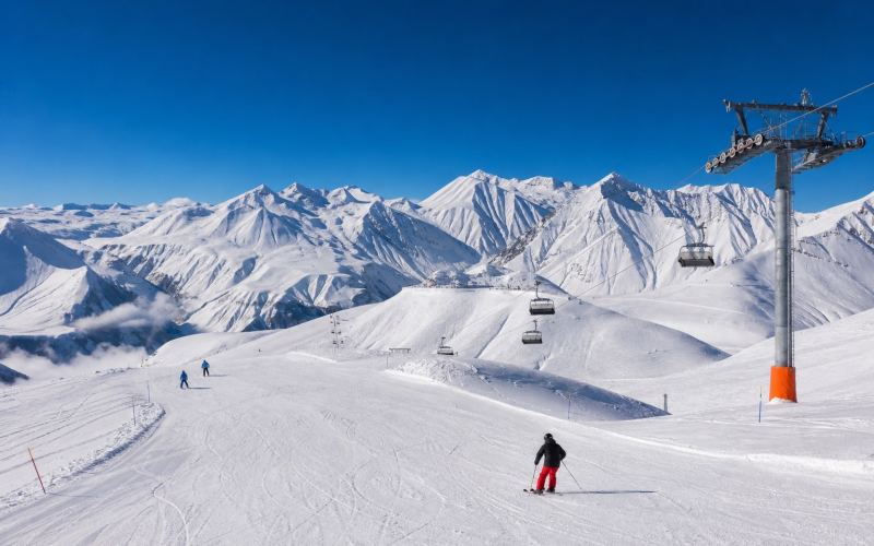 Ski slopes, a ski lift, and snow-capped peaks of the Caucasus in Gudauri