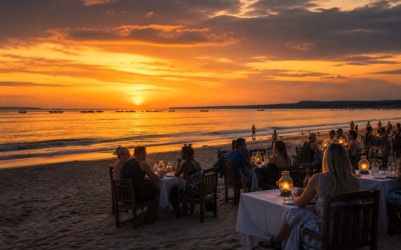 Seafood restaurant tables on the sand and sunset over Jimbaran Bay