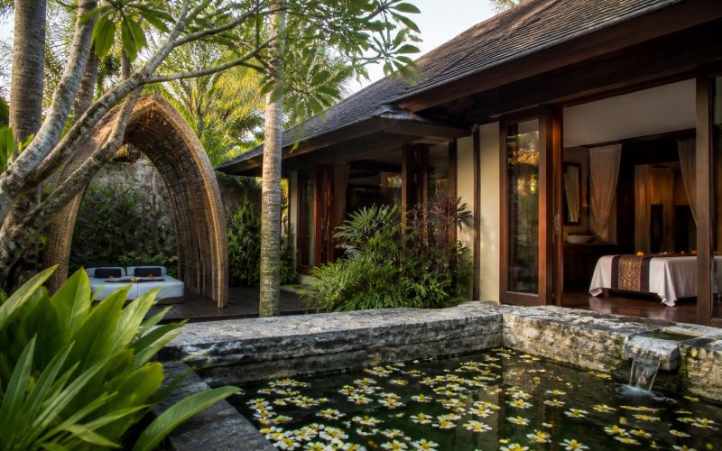 A tranquil courtyard spa with a pond and tropical garden in Seminyak