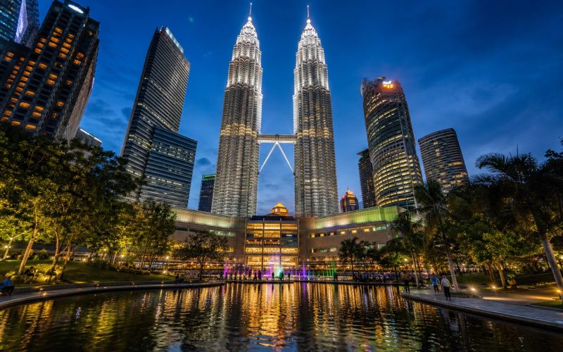 Башни Петронас и парк KLCC в вечерней панораме Куала-Лумпура