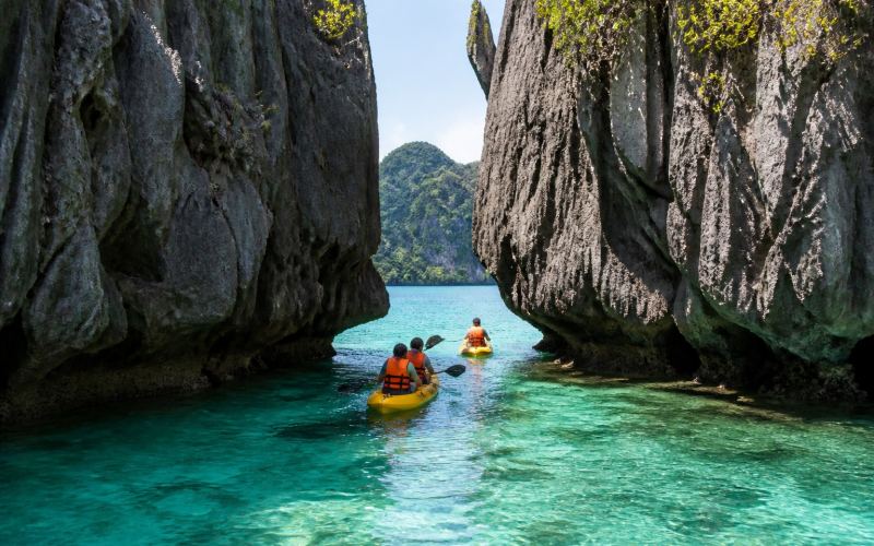 Kayaking in the clear waters of El Nido's Big Lagoon between limestone cliffs