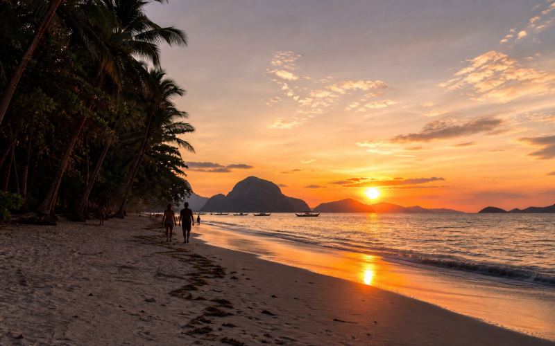 Sunset over the islands of Bacuit Bay near Las Cabanas Beach in El Nido