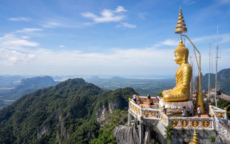 A golden Buddha statue and mountain views at Tiger Cave Temple in Krabi