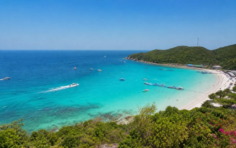 A turquoise bay, white beach, and boats off Koh Larn Island near Pattaya